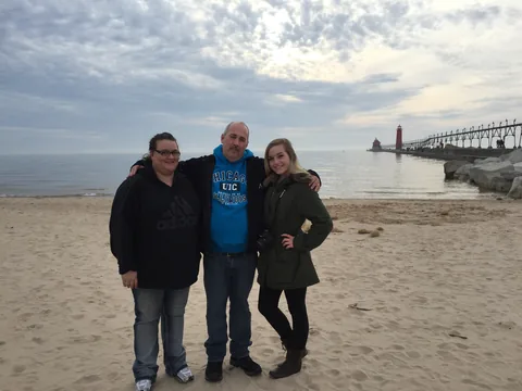 Roger with his daughters on the beach beside the Grand Haven pier